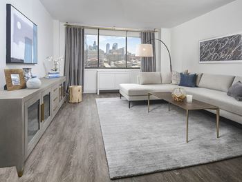 A modern living room with a large window overlooking the city.